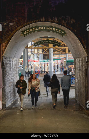London, Regno Unito - Aprile, 2019. Turisti e locali di mangiare e fare shopping nel Mercato di Borough, uno dei più antichi e più grande mercato alimentare a Londra. Foto Stock