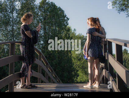 Tre donne sul ponte si prende le immagini degli altri due. Foto Stock