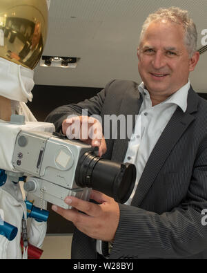 Oberkochen, Germania. 01 Luglio, 2019. Vladan Blahnik, testa lente di sviluppo, sorge accanto ad una tuta spaziale nel Museo Zeiss, il quale è montato con un Hasselblad medio formato fotocamera con un obiettivo Carl Zeiss®. La società sveva sviluppato speciali lenti per la NASA Moonlight Programma, con la quale, tra le altre cose, la prima foto sono state scattate sulla luna nel luglio 1969. (A DPA: 'lenti per la luna" - lenti dell'Apollo voli proveniva dalla Svevia') Credito: Stefan Puchner/dpa/Alamy Live News Foto Stock