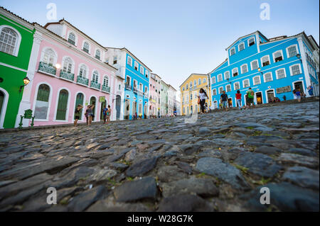 SALVADOR, Brasile - 12 febbraio 2018: pedoni a piedi nella vasta plaza Circondato da colorati edifici coloniali nel centro storico di Pelourinho. Foto Stock