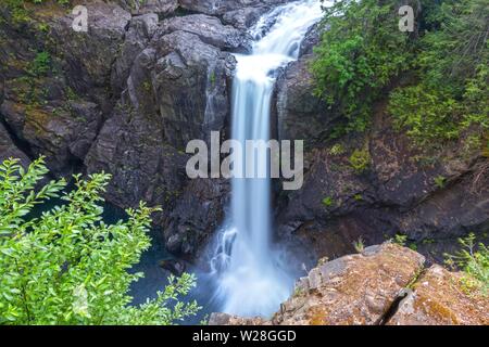 Paesaggio panoramico vista della cascata alta del flusso di acqua che scorre in cascata al Rock Canyon in Elk Falls provinciale Parco Natura sull'Isola di Vancouver Foto Stock