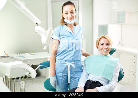 Medico e paziente sono ragazza sorridente in ufficio dal dentista. Foto Stock