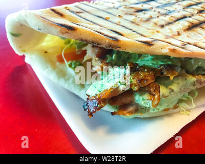 Turco piccante Döner Kebab riempiti con carne arrosto e insalata fresca e salsa di aglio in tortilla tostato. Foto Stock