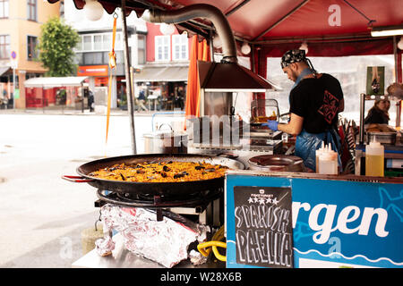 Una grande padella di paella spagnola per la cottura di un alimento in stallo il mercato del pesce su Strandkaien a Bergen, Norvegia. Foto Stock