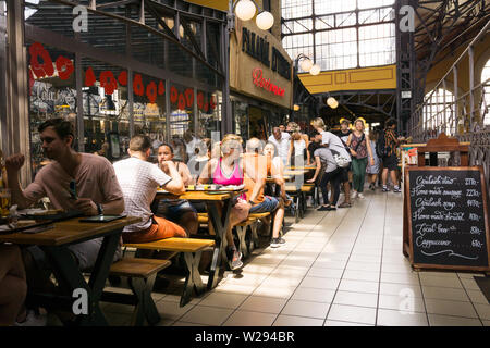I turisti havin pranzo presso un ristorante presso la Grande Sala del mercato in Budapest, Ungheria. Foto Stock