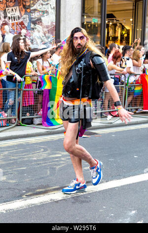 6 Luglio 2019 - Uomo con capelli lunghi vestito in PVC, colpendo una posa, London Pride Parade, REGNO UNITO Foto Stock