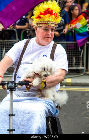 6 Luglio 2019 - Uomo su una mobilità scooter tenendo un barboncino, London Pride Parade, REGNO UNITO Foto Stock