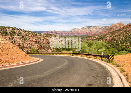 Sedona Arizona. Curva di tornitura su tortuosa strada di montagna attraverso il paesaggio mozzafiato di rocce rosse arenaria montagne e buttes. Foto Stock