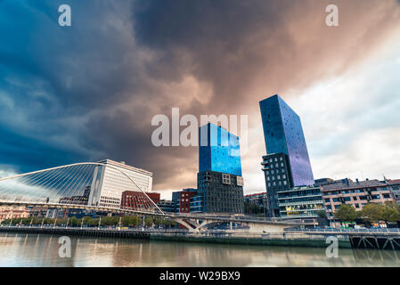 Bilbao, Spagna, 16/10-18. Mighty nuvole temporalesche sono la formazione su Bilbao e le torri di Isozaki e il ponte Zubizuri. Foto Stock