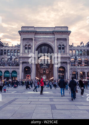 Milano, Italia, 09/11-18. I turisti si sono riuniti in Piazza del Duomo per fotografie, una donna in rosso è al centro della foto. Foto Stock