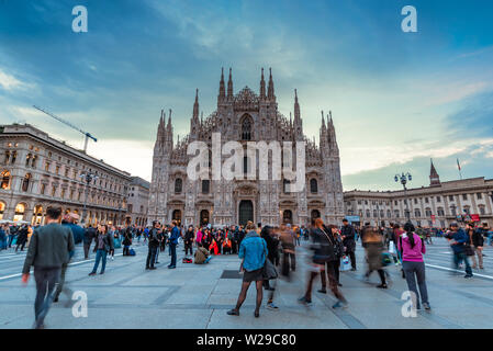 Milano, Italia, 09/11-18. I turisti si sono riuniti in Piazza del Duomo per fotografie. Una donna è in piedi al centro della foto controllando il suo telefono. Foto Stock