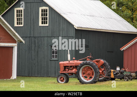 Agricoltura Sfondo. Trattore antico rosso e fienile tradizionale nel Midwest americano. Foto Stock