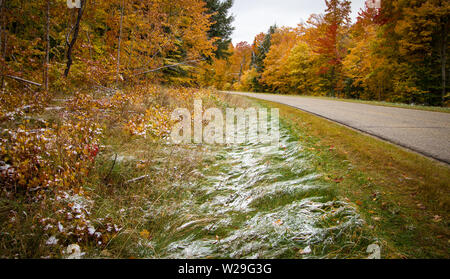 Michigan rurale strada asfaltata. La diminuzione di due corsie attraverso una foresta di autunno nella Penisola Superiore del Michigan. Foto Stock