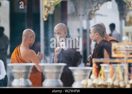 Yangon, Myanmar - Marzo 2019: i monaci buddisti hanno una discussione in Shwedagon pagoda tempio complesso. Foto Stock