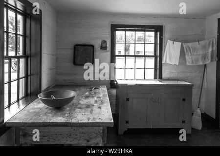 Cucina di paese interiore. Cucina, stile rustico con il cucchiaio di legno e ciotola su antiche tavolo in legno con uno stendibiancheria in angolo Foto Stock