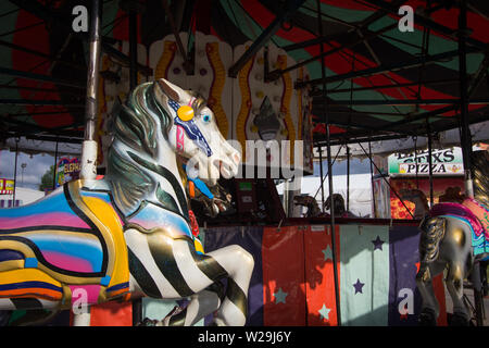 Cheboygan, Michigan, Stati Uniti d'America - 9 Agosto 2018: Close up di coloratissimi Giostra cavalli sul Merry Go Round a Cheboygan County Fair Foto Stock