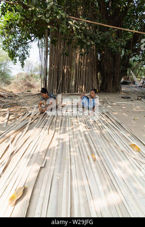 Bagan, Myanmar - Marzo 2019: vecchia donne birmane tessitura tappeti di bambù nel villaggio di Bagan Foto Stock