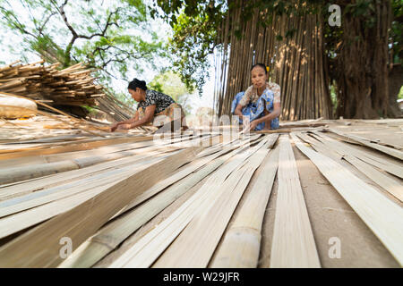 Bagan, Myanmar - Marzo 2019: vecchia donne birmane tessitura tappeti di bambù nel villaggio di Bagan Foto Stock