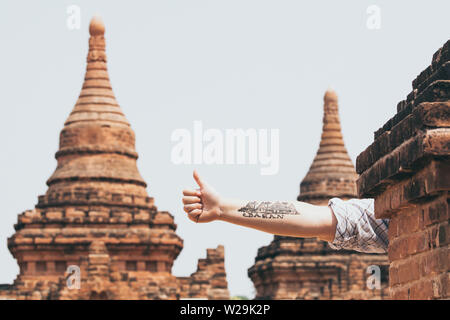 Bagan, Myanmar - Marzo 2019: a mano con un tatuaggio che mostra i templi e pagode di antica Bagan sullo sfondo Foto Stock