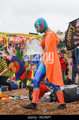 Brighton Regno Unito 7 Luglio 2019 - concorrenti vestito di wrestling messicano outfits per prepararsi a questo anni racchetta intorno al molo festival sulla spiaggia di Brighton . La paletta annuale intorno al molo è ora la più grande spiaggia libera di festival in Europa la raccolta di fondi per varie associazioni caritative compresi Surfers against Sewage . Credito : Simon Dack / Alamy Live News Foto Stock