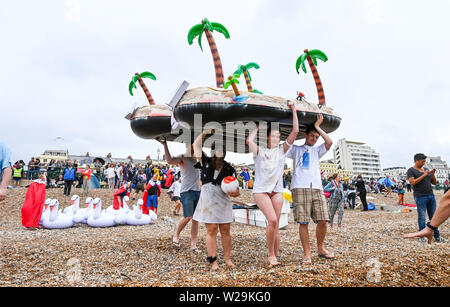 Brighton Regno Unito 7 Luglio 2019 - concorrenti preparare per questo anni racchetta intorno al molo festival sulla spiaggia di Brighton . La paletta annuale intorno al molo è ora la più grande spiaggia libera di festival in Europa la raccolta di fondi per varie associazioni caritative compresi Surfers against Sewage . Credito : Simon Dack / Alamy Live News Foto Stock