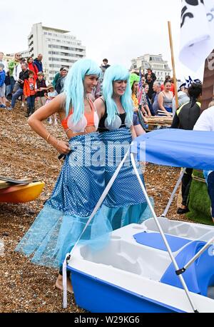 Brighton Regno Unito 7 Luglio 2019 - concorrenti preparare per questo anni racchetta intorno al molo festival sulla spiaggia di Brighton . La paletta annuale intorno al molo è ora la più grande spiaggia libera di festival in Europa la raccolta di fondi per varie associazioni caritative compresi Surfers against Sewage . Credito : Simon Dack / Alamy Live News Foto Stock
