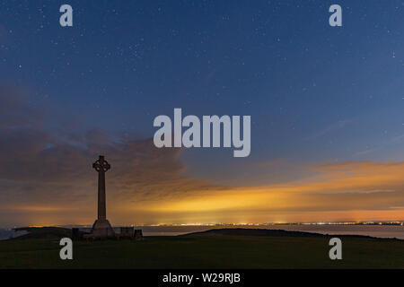 Tennyson monumento verso il basso guardando verso Ovest e attraverso il Solent durante il blu ora la sera dopo il tramonto. Foto Stock