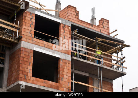 Costruzione di operai durante la costruzione di un nuovo complesso residenziale un edificio a più piani Foto Stock