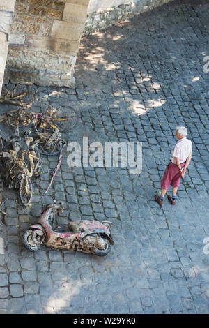 Un uomo guarda le biciclette e gli scooter, i ciclomotori, pescati fuori dalla Senna. Parigi, Francia. Foto Stock