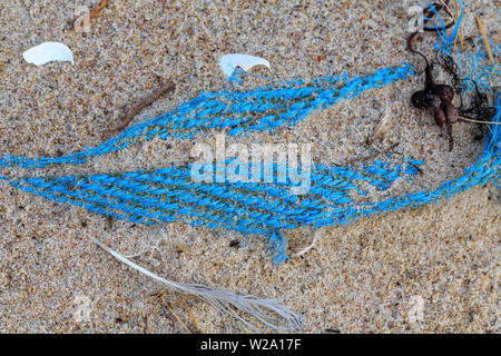 Inquinamento Ambientale - un vecchio blu net giacente su una spiaggia Foto Stock