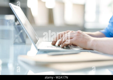 Mani di studente o un giovane imprenditore di toccare i tasti della tastiera del notebook Foto Stock