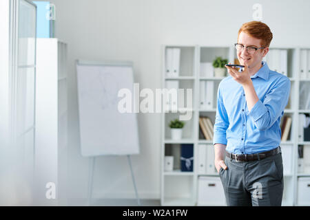 Bel giovane imprenditore la registrazione della sua voce su dictophone Foto Stock
