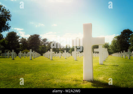 Primo piano di una croce bianca tomba militare in Normandia Cimitero Americano in una giornata di sole, Colleville-sur-Mer, Francia. Con copia spazio. Foto Stock