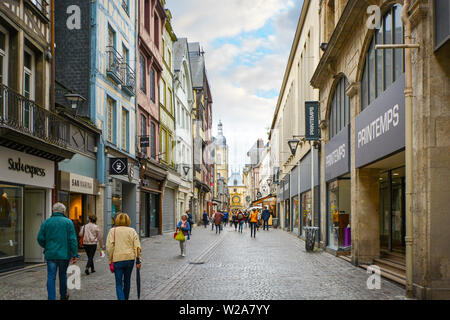 Il turista a godere di una passeggiata lungo i negozi di Rue du Gros Orloge a rouen Francia con l'orologio astronomico in background. Foto Stock