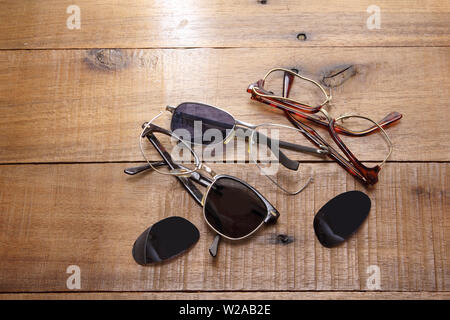 Rotto gli occhiali da sole su sfondo di legno Foto Stock