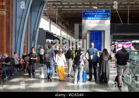 St Pancras London REGNO UNITO; i passeggeri ferroviari guardando alla partenza del treno di bordo su piattaforma, St Pancras International stazione ferroviaria London REGNO UNITO Foto Stock