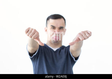 Il gesto e concetto di persone - infelice uomo asiatico che mostra il pollice verso il basso su sfondo bianco con spazio di copia Foto Stock