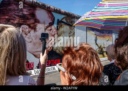 Brezhnev Honecker Kiss, quattro Signore che lo guardano, East Side Wall Gallery, Berlino Muro turisti Germania Friedrichshain città strada Foto Stock