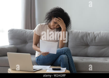 Sottolineato donna africana azienda fatture preoccupati circa il fallimento del debito bancario Foto Stock