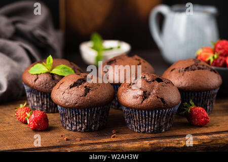 Fatti in casa muffin al cioccolato sul tagliere di legno, orientamento orizzontale Foto Stock