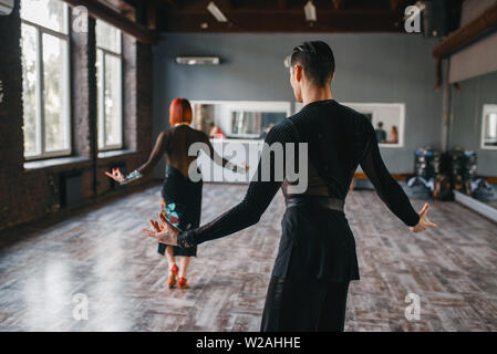 L uomo e la donna sulla ballrom danza di formazione in classe. Maschi e femmine di partner professionali sulla coppia danzante in studio Foto Stock