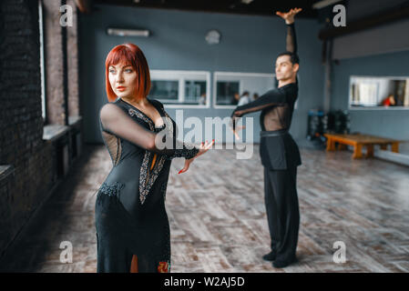 L uomo e la donna sulla ballrom danza di formazione in classe. Maschi e femmine di partner professionali sulla coppia danzante in studio Foto Stock