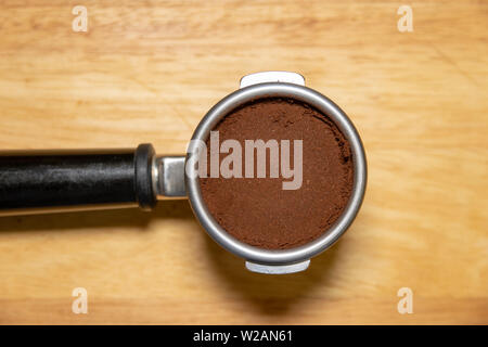 Portafilter sulla tabella riempita con caffè macinato Foto Stock