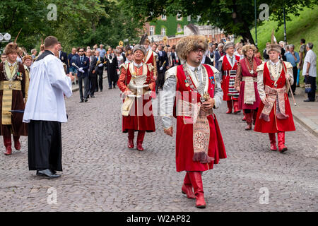 I partecipanti prendono parte a una processione per la Chiesa cattolica la festa del Corpus Domini, in strade della citta' vecchia di Cracovia, in Polonia Foto Stock