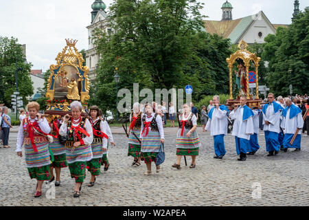 I partecipanti prendono parte a una processione per la Chiesa cattolica la festa del Corpus Domini, in strade della citta' vecchia di Cracovia, in Polonia Foto Stock