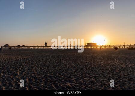 Sagome di persone su Huntington Beach Pier durante il tramonto Foto Stock