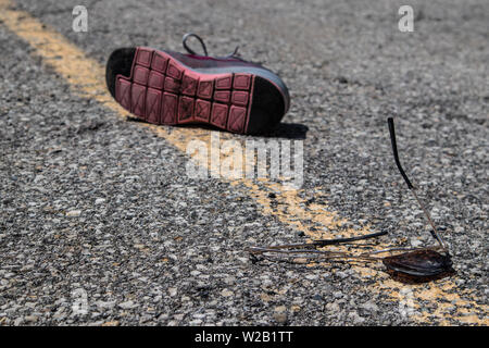 Incidente stradale: su asfalto irregolare, vetri rotti e una scarpa persa .. Foto Stock