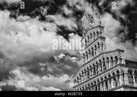 San Michele in Foro chiesa medievale bella facciata romanica nella città di Lucca, Toscana, eretto nel XIII secolo con le nuvole e copia spa Foto Stock