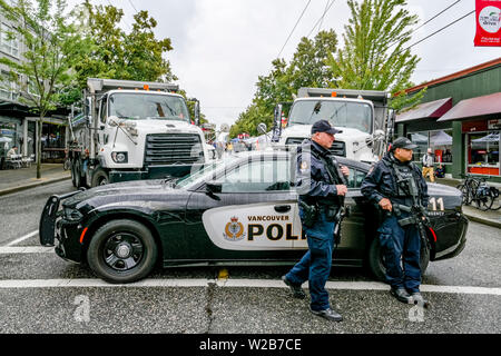 Cooperazione di polizia con armi automatiche e di autocarri con cassone ribaltabile guard accesso alle unità commerciali, la Giornata senza automobili, Vancouver, British Columbia, Canada Foto Stock