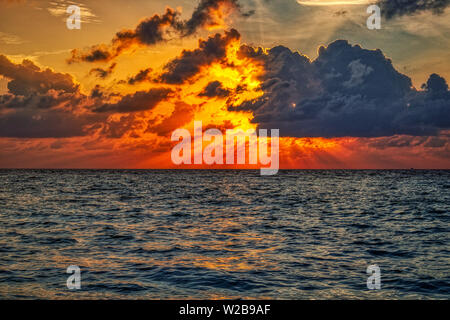 Questa unica immagine mostra il gigantesco tramonto alle Maldive. Si può facilmente vedere come il cielo raffiche e tutto diventa arancione Foto Stock